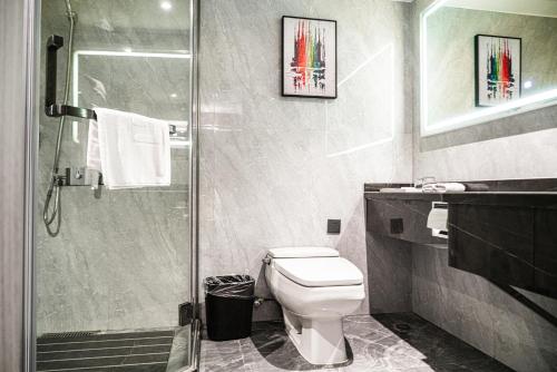 a bathroom with a toilet and a glass shower at 长沙荔高尊享酒店 in Changsha