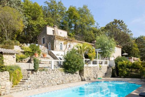 une maison avec un mur en pierre et une piscine dans l'établissement Magnifique villa 