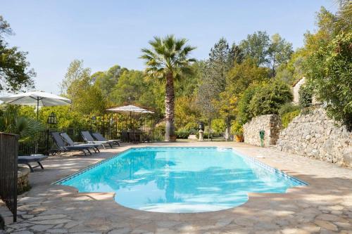 une piscine dans une cour avec un palmier dans l'établissement Magnifique villa 