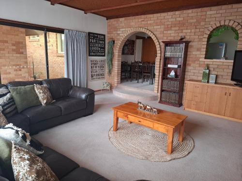 a living room with a couch and a coffee table at PAK House Central - Spacious 4 Bedroom New Listing! in Echuca