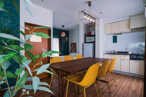 a kitchen and dining room with a table and yellow chairs at House YOYOGI Park, Shibuya Area, 4 Minutes to Yoyogi Park, 4-Bedroom, Sleeps 8 in Tokyo