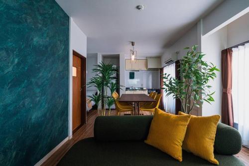 a living room with a green couch and a dining room at House YOYOGI Park, Shibuya Area, 4 Minutes to Yoyogi Park, 4-Bedroom, Sleeps 8 in Tokyo