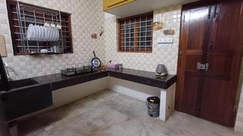 a kitchen with a black counter top and a window at SHI's Kurunji 5BHK Villa in Pollachi in Pollāchi