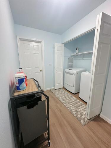a small kitchen with a refrigerator and a laundry room at Easystay in Fairbanks