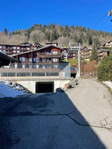 un parcheggio vuoto di fronte a un edificio di Studio cabine cosy à 5min à pieds des pistes et du centre ville a Les Gets