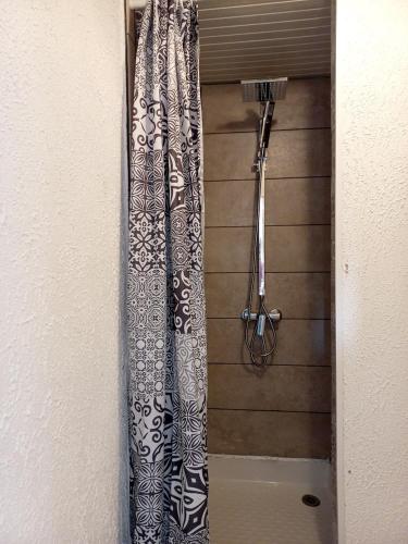 une douche avec rideau de douche noir et blanc dans l'établissement Studio du départ pour les îles Quiberon, à Quiberon