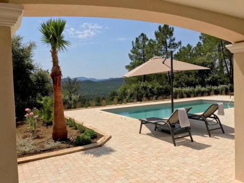 - une terrasse avec une table et un parasol à côté de la piscine dans l'établissement Holiday Home in Le Plan-de-la-Tour with Pool, au Muy