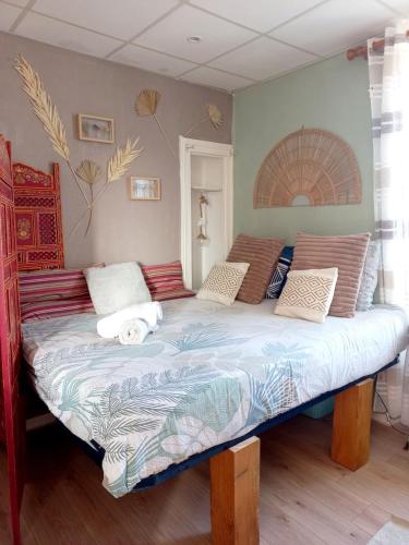 une chambre avec un grand lit avec des oreillers dessus dans l'établissement Studio du départ pour les îles Quiberon, à Quiberon