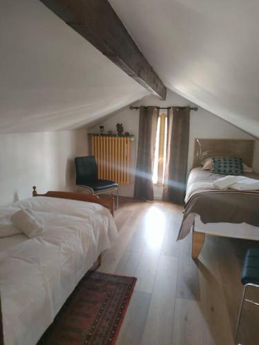 une chambre avec deux lits et une chaise dans l'établissement Maison chaleureuse près Disney, à Villenoy