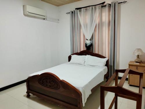a bedroom with a wooden bed with a window at ECO Canal Suite in Polonnaruwa