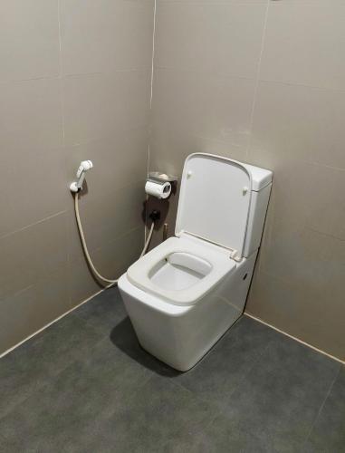 a bathroom with a white toilet in a stall at ECO Canal Suite in Polonnaruwa