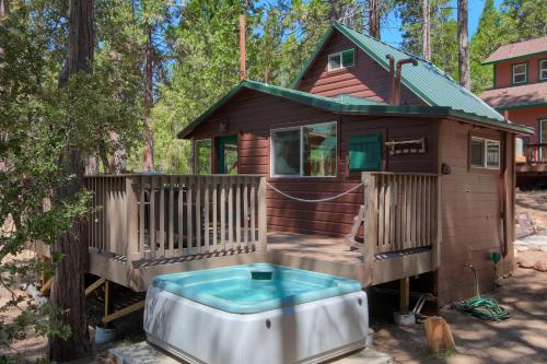 une cabane dans les arbres avec un bain à remous en face de celle-ci dans l'établissement Beetlebark Bungalow- Inside Yosemite w/ hot tub EV charging cable, à North Wawona