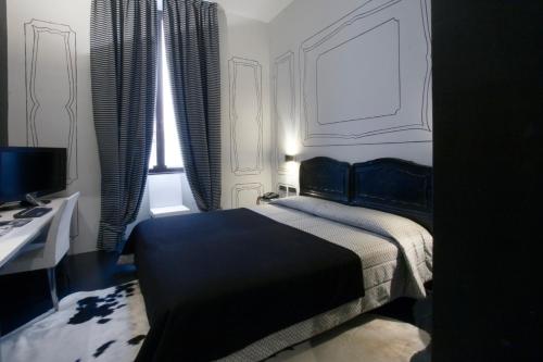 a bedroom with a bed and a desk and windows at Art Hotel Boston in Turin