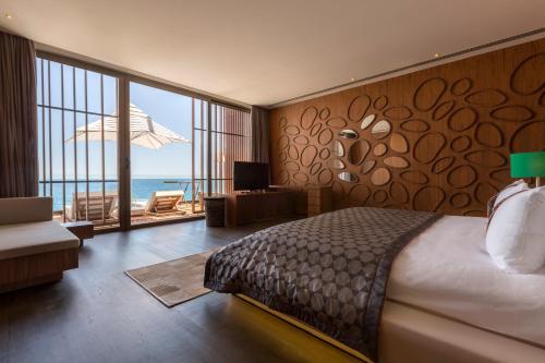 a bedroom with a bed and a view of the ocean at Maxx Royal Kemer Resort in Kemer