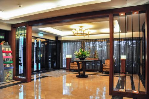 a lobby with a table and chairs in a building at Jingan Classic Inn in Zhonghe