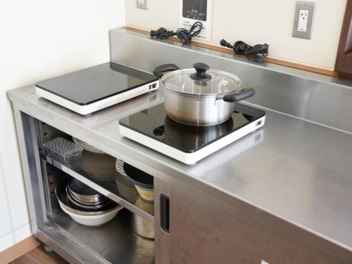 a pot on top of a stove in a kitchen at ハタラコリビングみなのsubako in Minano