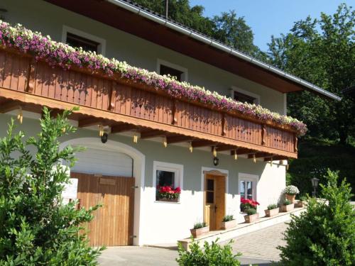 a house with a balcony with flowers on it at Apartment in Schwalbenhof farm in Haselbach