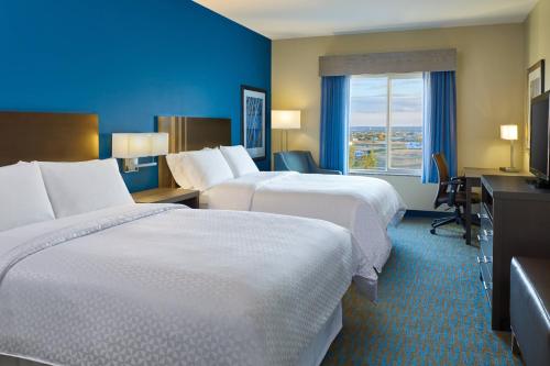 a hotel room with two beds and a desk at Four Points by Sheraton Williston in Williston