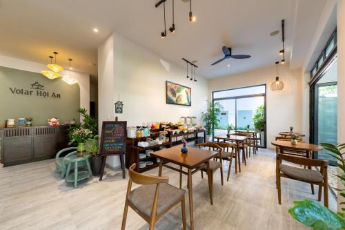 una sala da pranzo con tavoli e sedie in un ristorante di Volar Hoi An a Hoi An
