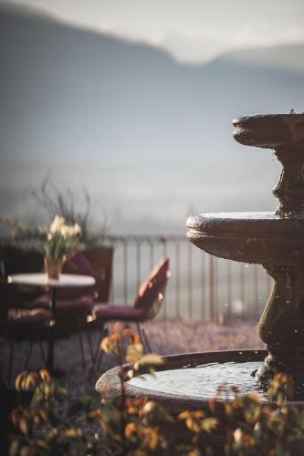 a view of a fountain with a table and chairs at Schloss Hotel Korb in Appiano sulla Strada del Vino