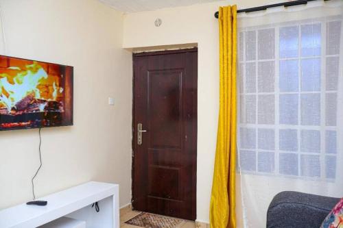 Habitación con puerta marrón y ventana en Nanasi Homes, en Thika