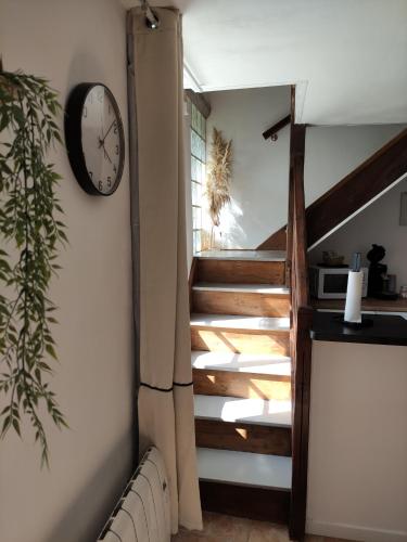 une horloge sur un mur à côté d'un escalier dans l'établissement Le cottage de Mercey, à Mercey