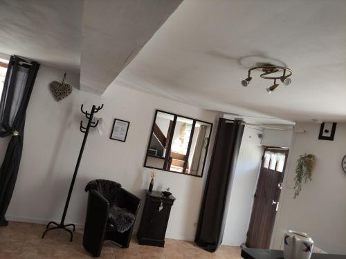 un salon avec des rideaux noirs et un mur blanc dans l'établissement Le cottage de Mercey, à Mercey