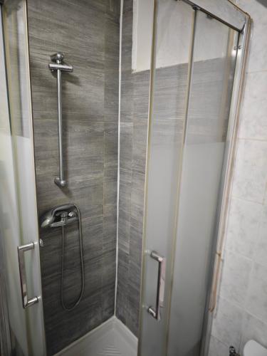 une douche avec une porte vitrée dans une salle de bain dans l'établissement Le Jarry à Gare de l'Est, à Paris