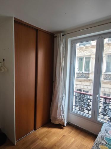 une chambre vide avec une porte et une fenêtre dans l'établissement Le Jarry à Gare de l'Est, à Paris