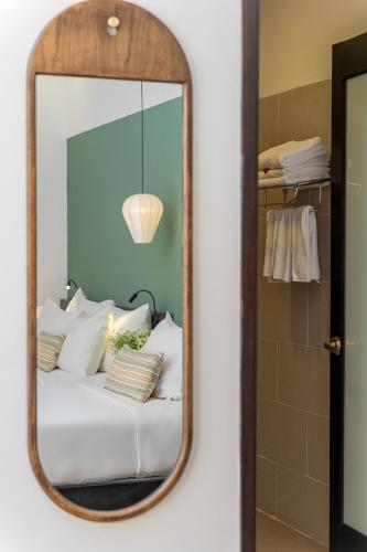 a mirror reflecting a bed with white pillows at Volar Hoi An in Hoi An