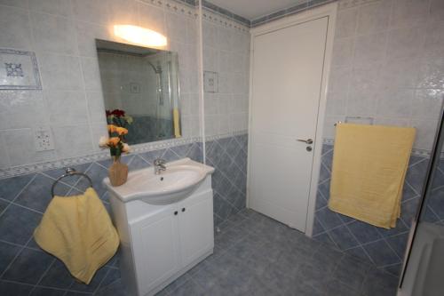un bagno con lavandino e specchio di Bay Villas a Pissouri