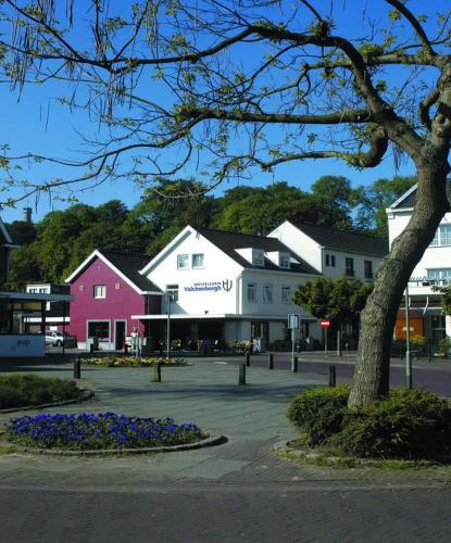 a town with white buildings and a tree and flowers at Hostellerie Valckenborgh - Lodging Only in Valkenburg
