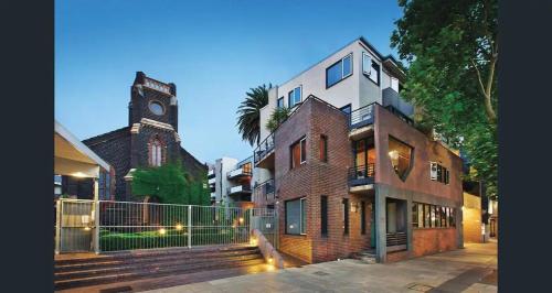 a building with a clock tower next to a church at Alameda Apartment St Kilda by Ready Set Stay in Melbourne