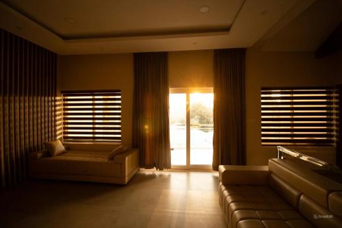 a living room with a couch and a window at Elixir Hills Suites Resort and Spa in Munnar