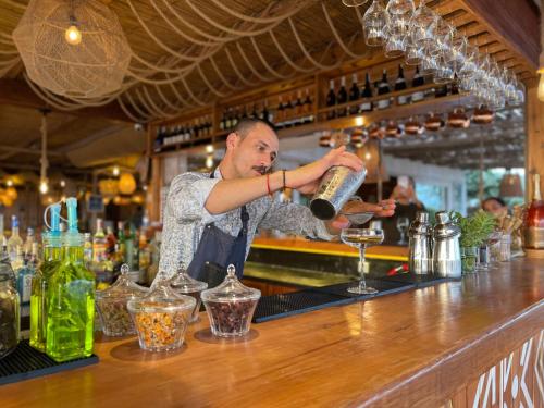 a man pouring a glass at a bar at Océan Vagabond Lassarga in Dakhla