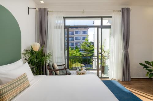 a bedroom with a large bed and a large window at Volar Hoi An in Hoi An