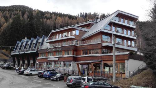 a large building with cars parked in front of it at Jolly Resort & Spa in Ponte di Legno