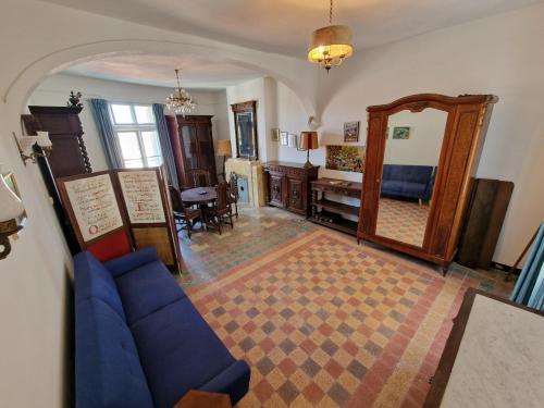 un salon avec un canapé bleu et un miroir dans l'établissement La Citadelle Médiévale - Appartement, à Béziers