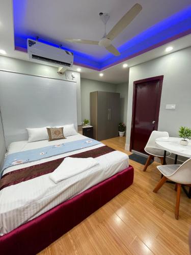 a bedroom with a large bed with a blue ceiling at Family Inn - Airport Hotel in Dhaka