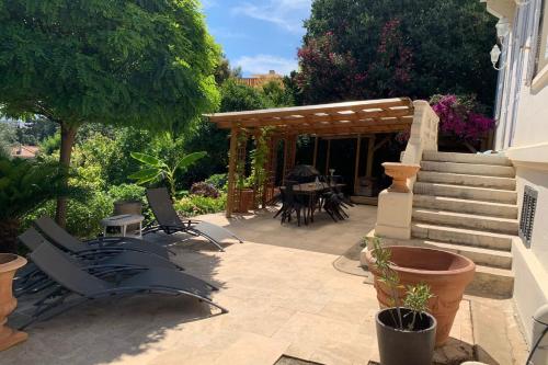 une terrasse avec des chaises et une pergola en bois. dans l'établissement 06BI2 - Beautiful apartment with garden and terrace, au Cannet