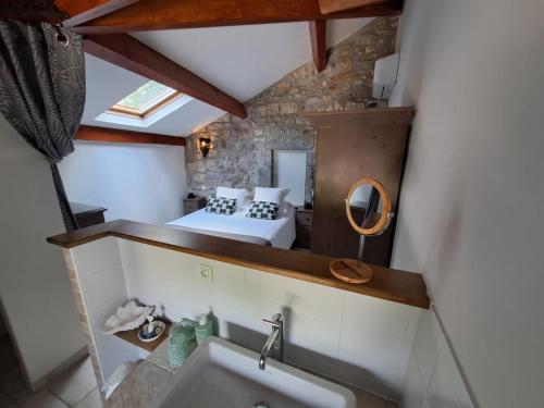 a bathroom with a bed and a sink in a room at L Antre de Pierres - chambres d'hôtes et gites in Berrias Et Casteljau