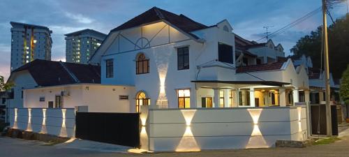 a white house with lights in front of it at Austin Melaka in Kampong Sungai Putat