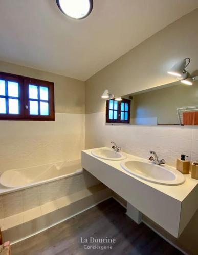 une salle de bain avec deux lavabos et un grand miroir dans l'établissement Villa La Cantina, piscine, à Lège-Cap-Ferret