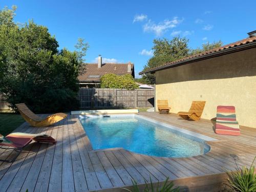 une cour arrière avec une piscine et une terrasse en bois dans l'établissement Villa La Cantina, piscine, à Lège-Cap-Ferret