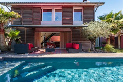 a house with a swimming pool in front of a house at Villa des 4 vents in Capbreton
