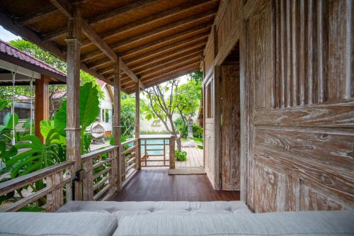 an open porch of a house with a bed at Meraki Luxury Villa in Pemuteran