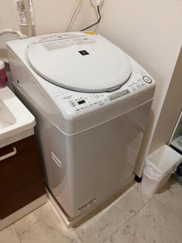 a washing machine with a toilet seat on top of it at Check in is available from 12 PM Yokkaichi Miyamadocho House B in Yokkaichi
