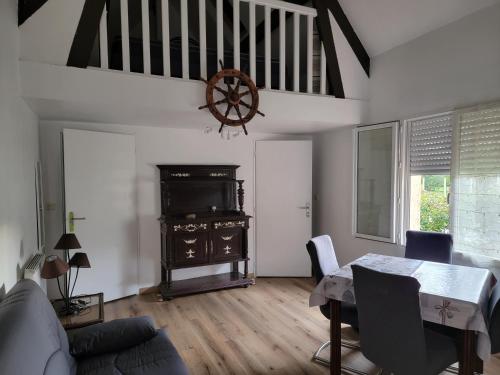 - un salon avec une table à manger et une roue dans l'établissement Gite Feugas, à Assat