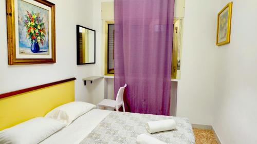 a bedroom with a bed and a purple curtain at Fly me to Venice in Campalto