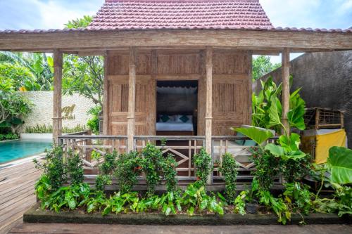 a wooden gazebo on a deck next to a pool at Meraki Luxury Villa in Pemuteran